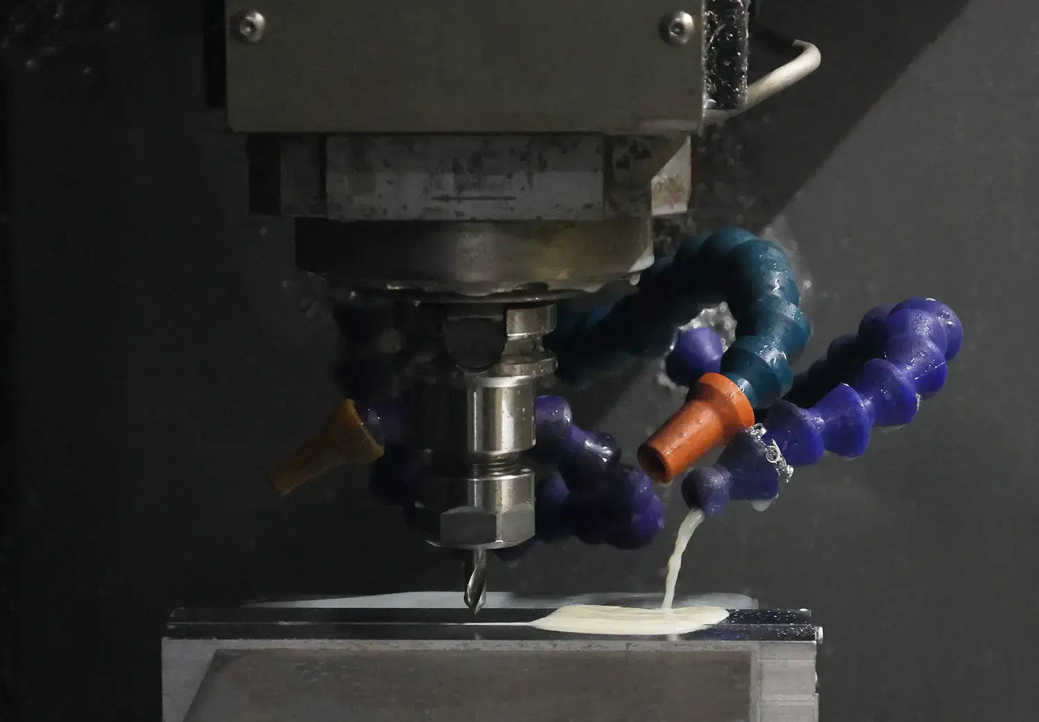 CNC milling machine cutting metal workpiece with coolant for precision custom parts manufacturing
