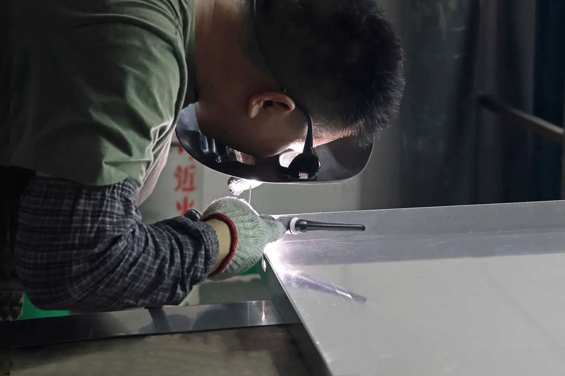 Professional welder performing TIG welding on sheet metal components