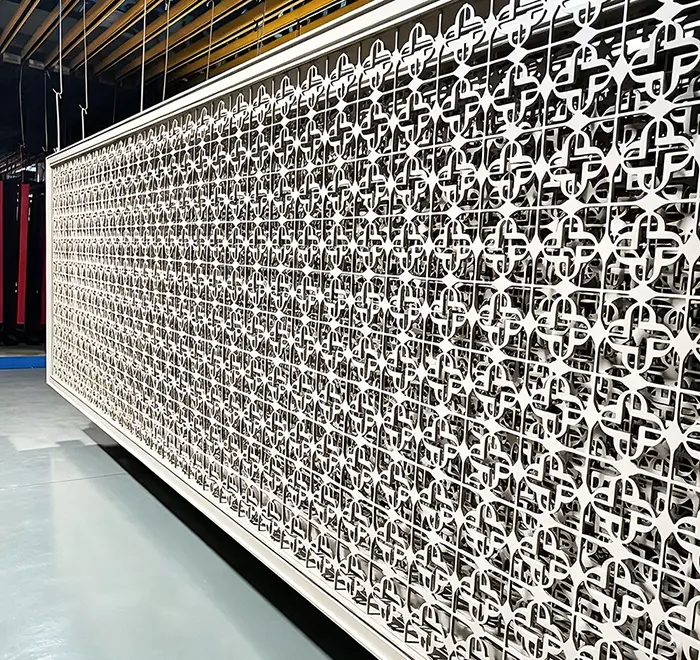 Powder-coated, laser-cut metal screen panel for an architectural facade.