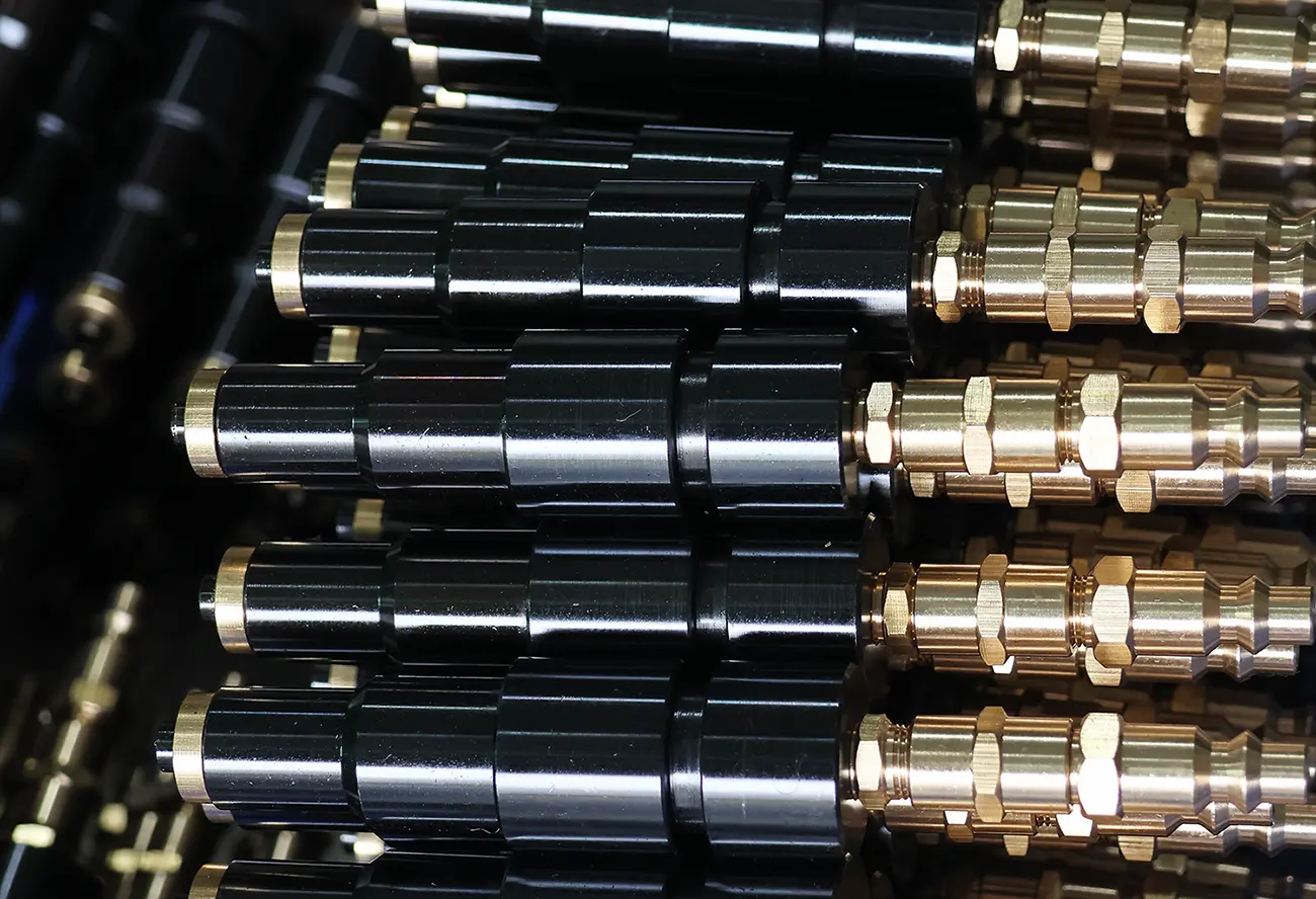 Batch of aluminum-and-brass cylindrical valve parts
