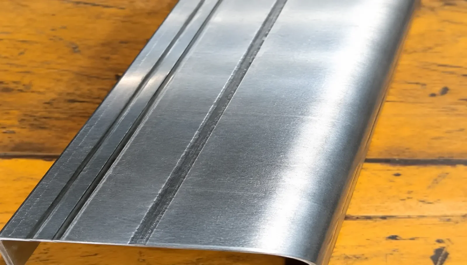 Visible press brake bend marks on a formed sheet metal surface